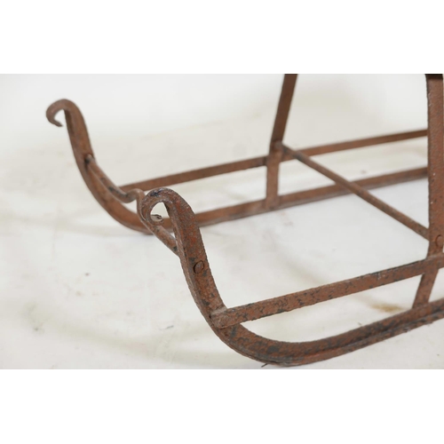 1174 - An antique child's sled, wrought iron with a wood seat, 32