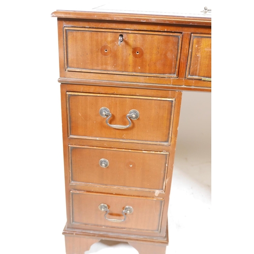 1199 - A mahogany pedestal desk with a tooled inset top, hidden keyboard drawer/slide, drawers and a cupboa... 