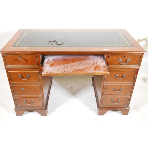 1199 - A mahogany pedestal desk with a tooled inset top, hidden keyboard drawer/slide, drawers and a cupboa... 