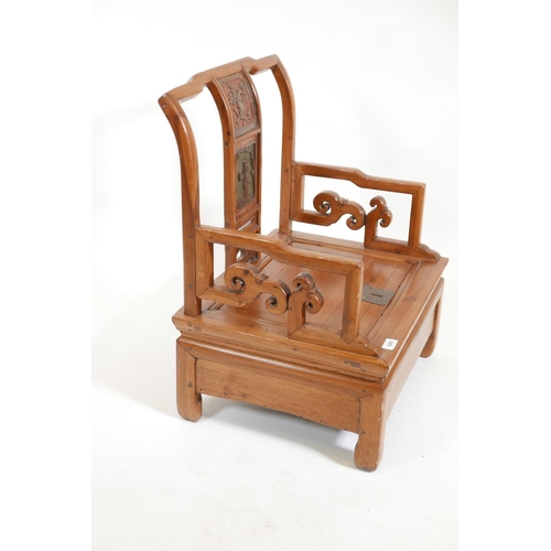 1209 - A Chinese fruitwood low commode chair with carved and painted decoration to the back splat, 21