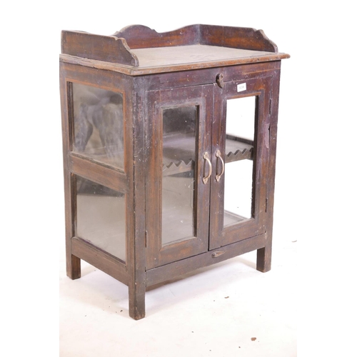 1238 - An Indian teak two door cabinet with glazed doors and sides (one glass missing), and a three quarter... 