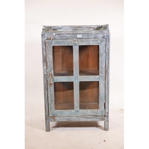 1239 - An Indian hardwood single door display cabinet with three quarter gallery top and glazed sides, rais... 