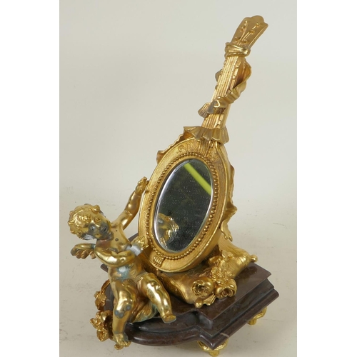 124 - A gilt bronze table mirror in the form of a lute with cherubs, on a marble base, 12