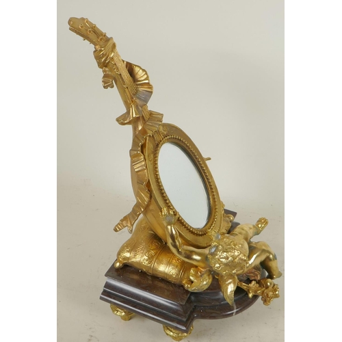 124 - A gilt bronze table mirror in the form of a lute with cherubs, on a marble base, 12