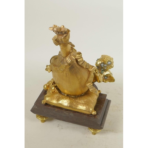 124 - A gilt bronze table mirror in the form of a lute with cherubs, on a marble base, 12