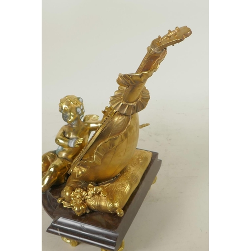 124 - A gilt bronze table mirror in the form of a lute with cherubs, on a marble base, 12