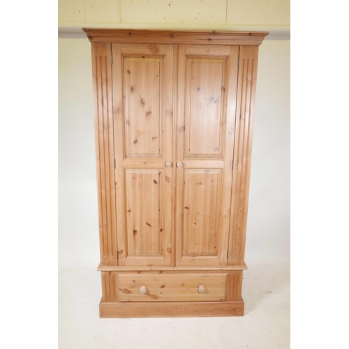 1241 - A pine two door wardrobe with a single drawer, raised on a plinth base, 43½