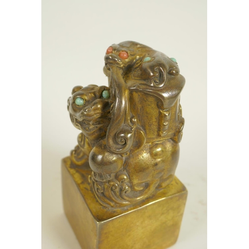 125 - A Chinese gilt bronze seal, the top formed as mythical beasts set with coloured stones, on square 5