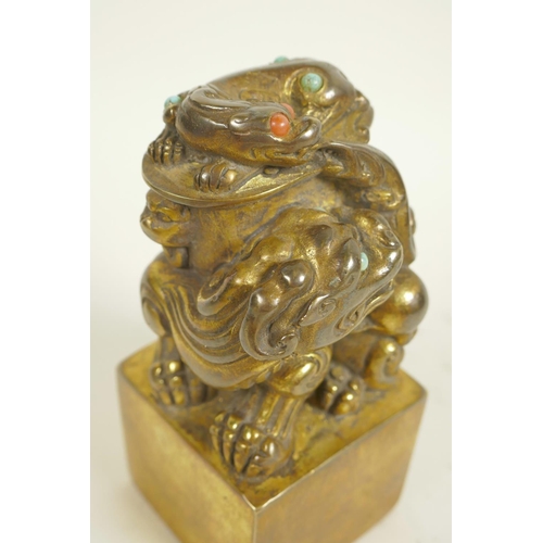 125 - A Chinese gilt bronze seal, the top formed as mythical beasts set with coloured stones, on square 5