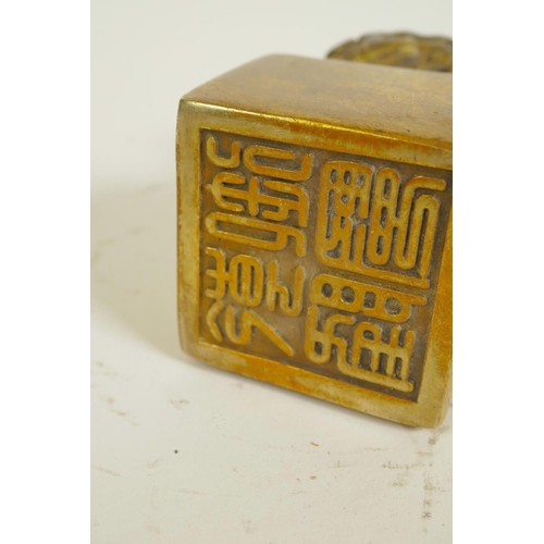 125 - A Chinese gilt bronze seal, the top formed as mythical beasts set with coloured stones, on square 5