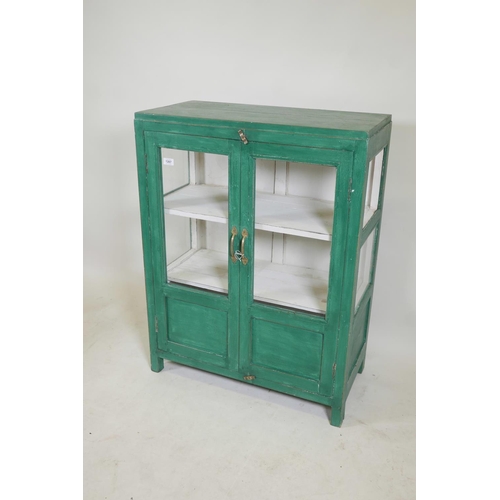 1287 - An Indian painted hardwood two door display cabinet, lacks one glass pane to side, 30