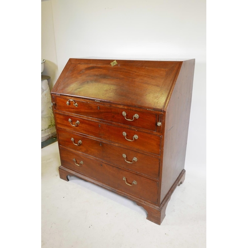 1290 - A Georgian mahogany fall front bureau, the fitted interior with secret drawer and slides over four l... 