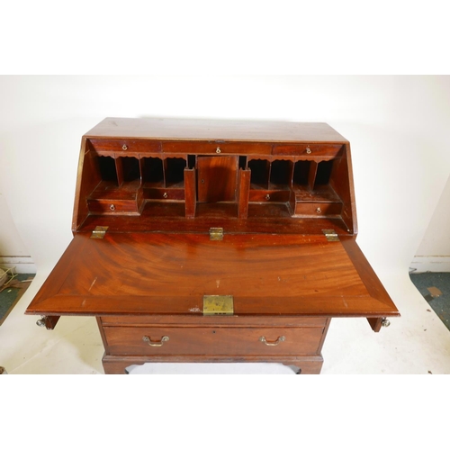 1290 - A Georgian mahogany fall front bureau, the fitted interior with secret drawer and slides over four l... 