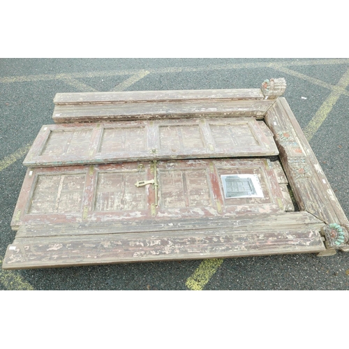 1292 - Architectural salvage: A pair of Indian teak storm doors and frame, with carved details, each door w... 