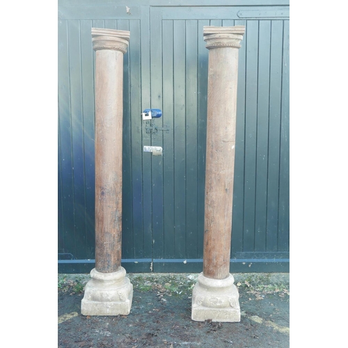 1300 - Architectural salvage: A pair of Indian teak columns with carved capitals, mounted on carved stone b... 