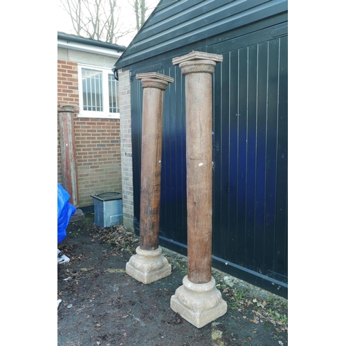 1300 - Architectural salvage: A pair of Indian teak columns with carved capitals, mounted on carved stone b... 