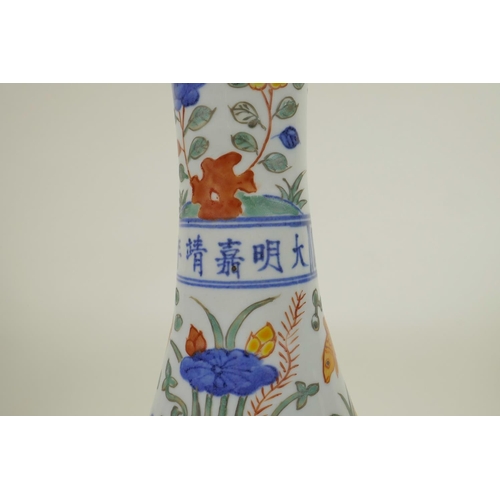 148 - A Chinese Wucai porcelain bottle vase decorated with carp in a lotus pond, 6 character mark to neck,... 