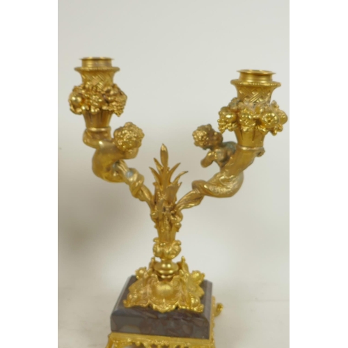 151 - A pair of ormolu two branch table candelabra, the sconces surrounded by bowls of fruit, and the stem... 