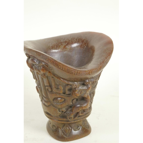 169 - A Chinese faux horn libation cup with mythical animal decoration, 5½