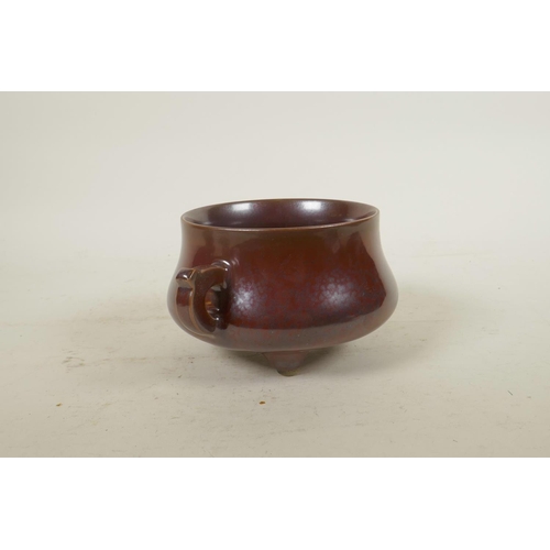 185 - A Chinese copper glazed porcelain censer with two handles, raised on tripod supports, impressed seal... 