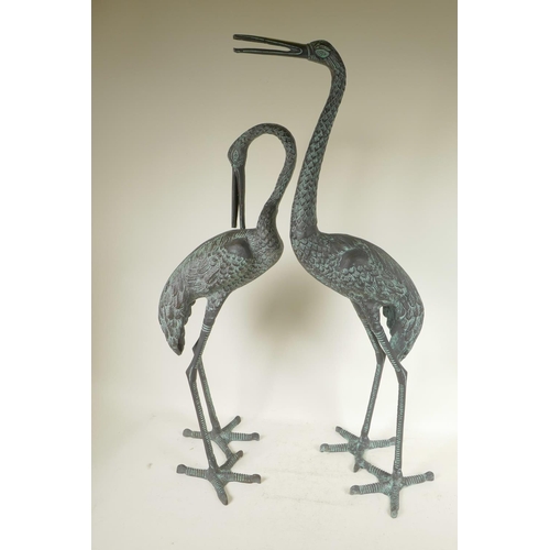 19 - A pair of patinated metal garden figures of cranes, largest 32½