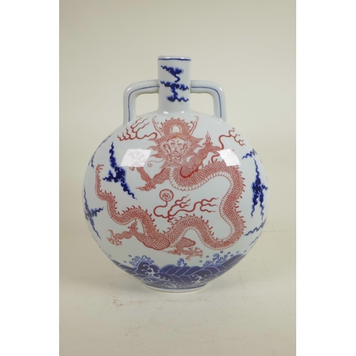 20 - A Chinese blue and white porcelain two handled moon flask decorated with a red dragon in flight