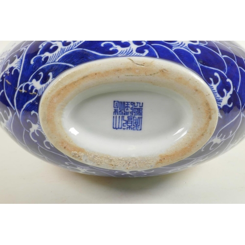 20 - A Chinese blue and white porcelain two handled moon flask decorated with a red dragon in flight