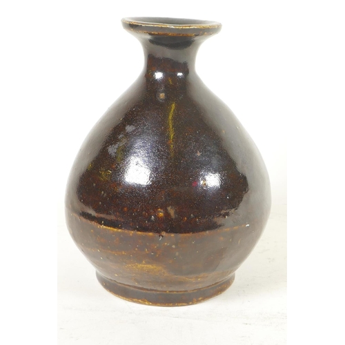 201 - A Japanese treacle glazed pottery wine flask of bulbous form with character inscription to base, 6¼