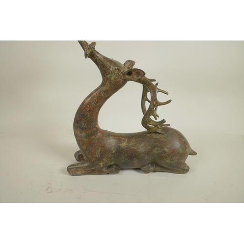 218 - An archaic style Chinese bronze figure of a deer supporting a candle/bowl stand, 13