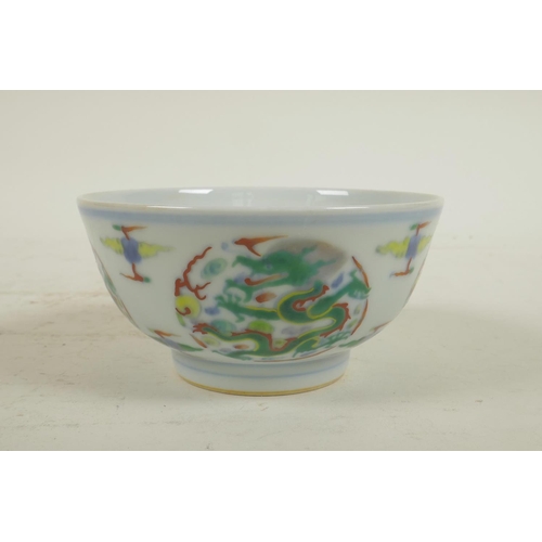 226 - A Chinese carved doucai porcelain rice bowl with enamelled dragon decoration, 6 character mark to ba... 