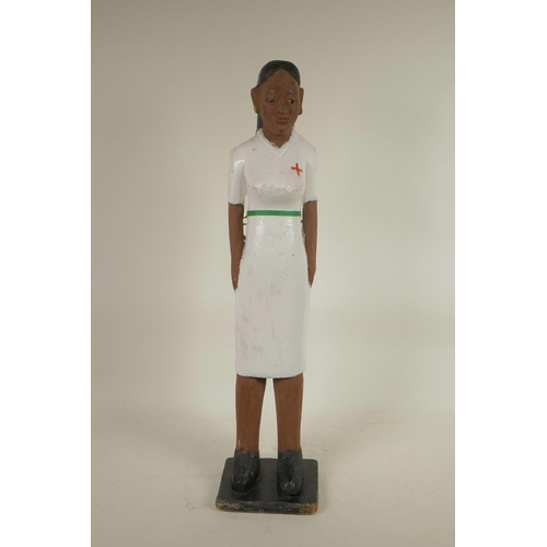 257 - An African carved and painted wood figure of a healthworker, 23