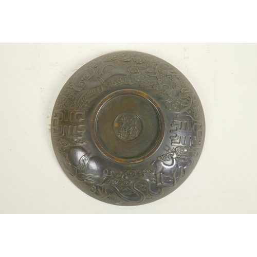 28 - A Chinese bronze dish with raised kylin and flaming pearl decoration, impressed 4 character mark to ... 