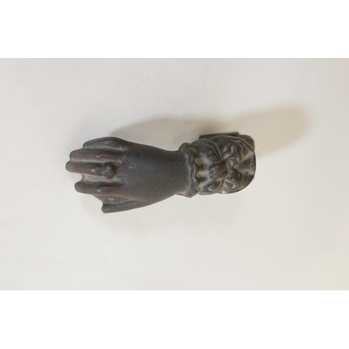 290 - A C19th cast iron door knocker in the form of a hand clutching a fruit