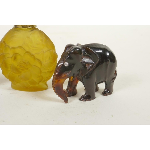 305 - Two miniature carved faux tortoiseshell elephants, together with two coloured glass scent bottles, 2... 