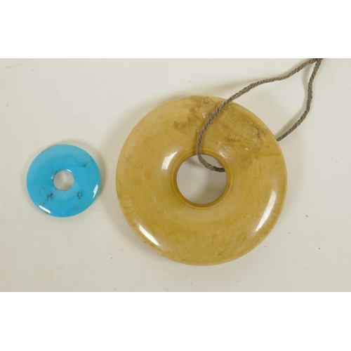 310 - A Chinese turquoise pi-disc pendant, and another larger composition pi disc, largest 2½