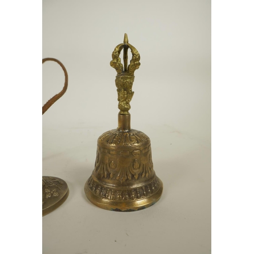 312 - A Tibetan metal bell with vajra decoration to handle, together with a similarly decorated set of min... 