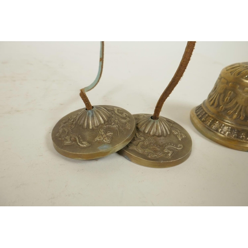 312 - A Tibetan metal bell with vajra decoration to handle, together with a similarly decorated set of min... 