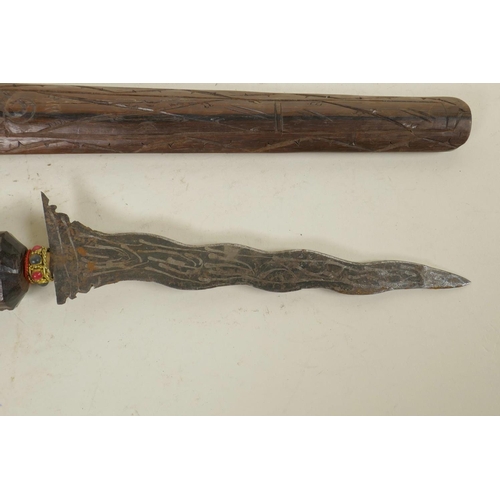 319 - An Indonesian kris with a traditional carved hardwood sheath and handle, 16½