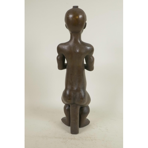 324 - An African bronze figure of a seated man, 14½