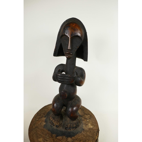 331 - An African carved hardwood figure mounted as the handle to a large lid, 19