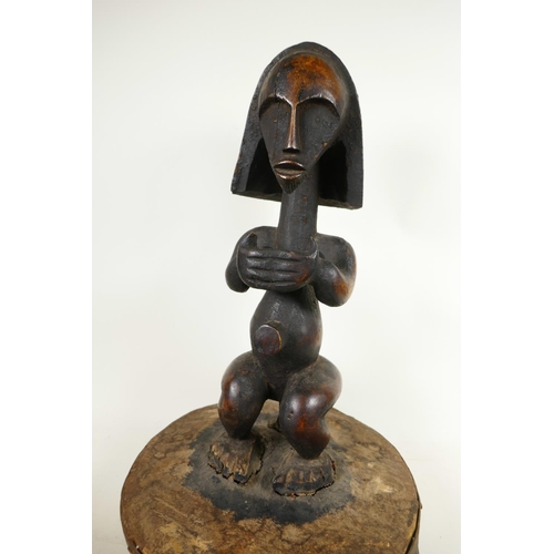 331 - An African carved hardwood figure mounted as the handle to a large lid, 19