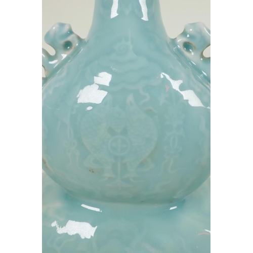 332 - A Chinese pale blue glazed porcelain double gourd vase with embossed decoration of dragons and fish,... 