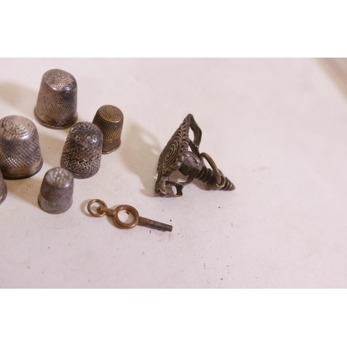 339 - A quantity of hallmarked silver and other thimbles, and brass key and eastern bronze stamp