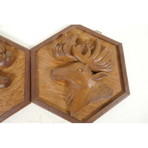 347 - A pair of carved wood wall plaques of stag heads on hexagonal frames, 8