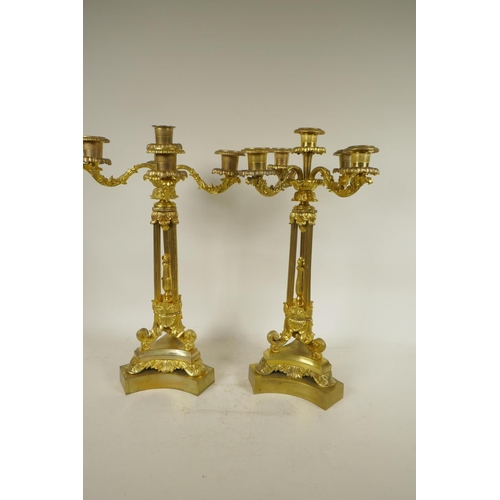 386 - A pair of ornate ormolu four branch candlesticks with triple reeded columns and triform base, all wi... 