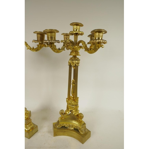 386 - A pair of ornate ormolu four branch candlesticks with triple reeded columns and triform base, all wi... 