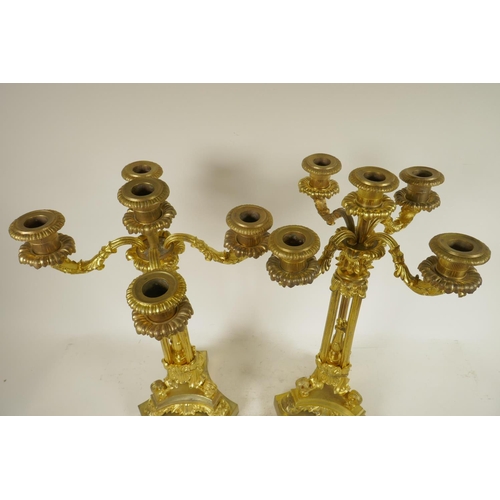 386 - A pair of ornate ormolu four branch candlesticks with triple reeded columns and triform base, all wi... 