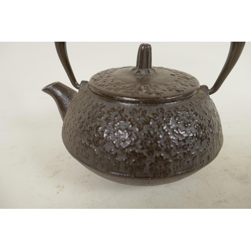 396 - A small Japanese iron teapot with all over floral decoration, 4¼