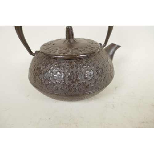 396 - A small Japanese iron teapot with all over floral decoration, 4¼