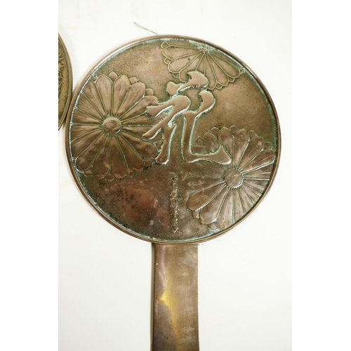 414 - Three earl C19th Japanese bronze hand mirrors, the backs decorated with flowers and calligraphy, lar... 